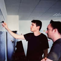 Two Keen employees working together writing on a whiteboard